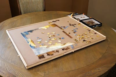 A jigsaw puzzle is in progress on a round table