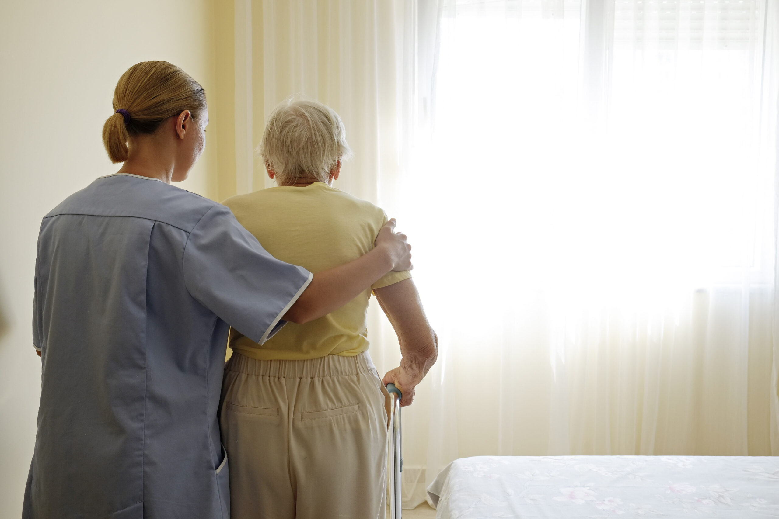 Caregiver assisting a senior resident in a bright room