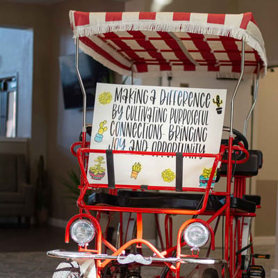 Colorful bicycle cart with a sign indoors