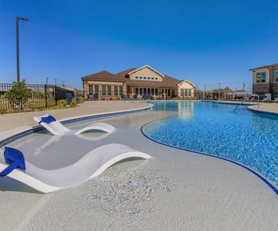 A scenic pool area with lounge chairs at Lavon Senior Villas