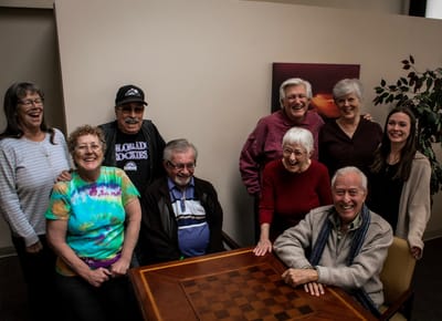 Residents and staff smiling together in a common area