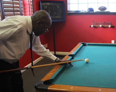 Resident playing billiards in a common area