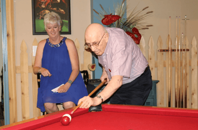 Residents enjoy a game of billiards in a common area