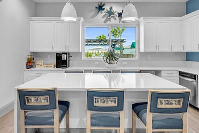 Modern kitchen area with seating and large windows