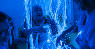 Staff engaging a resident with sensory lights in a therapeutic setting