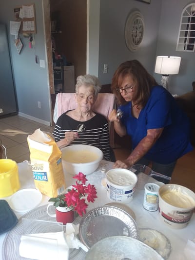 Resident enjoying baking activity with staff member