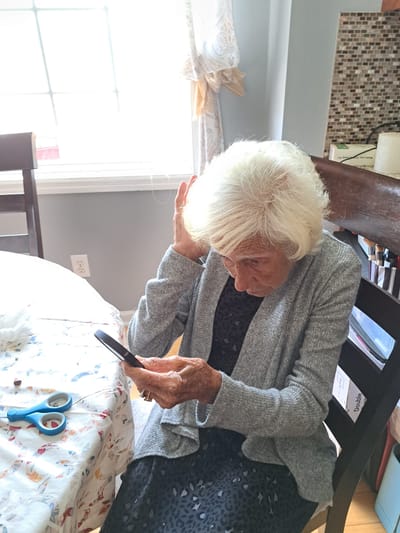 An elderly woman using a smartphone in an indoor setting