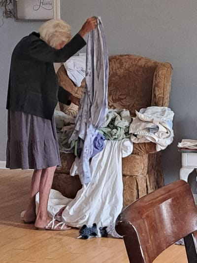 Resident folding laundry in a cozy common area