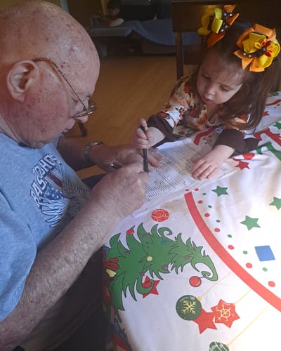 An elderly man and a child engaged in a creative activity