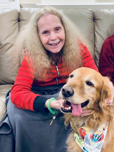 Resident smiling with a golden retriever dog