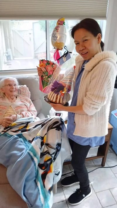 A staff member celebrating with a resident and cookies