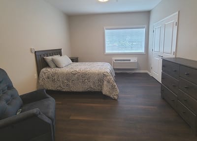 A well-furnished private resident room with bed and furniture