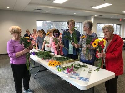 Residents participating in a flower arranging activity.
