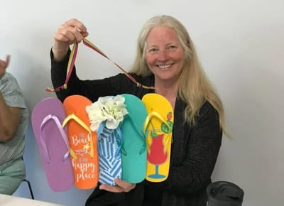Resident holding colorful flip flops at a celebration