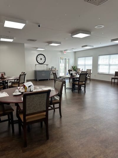 Dining room with tables and chairs, no residents present