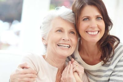 Riverside Manor, nursing home in Ames, IA — Two women smiling and embracing in a bright room