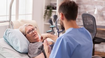 Riverside Manor, nursing home in Ames, IA — Nurse talking to a resident in a healthcare setting