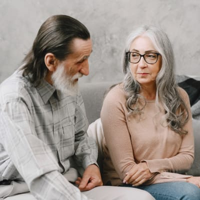 Riverside Manor, nursing home in Ames, IA — Two seniors engaged in conversation on a couch