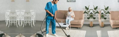 Care staff cleaning in a common area.