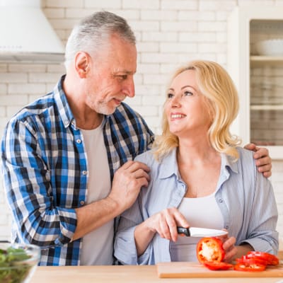 Riverside Manor, nursing home in Ames, IA — Couple preparing food together in a bright kitchen