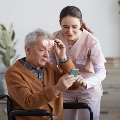 Riverside Manor, nursing home in Ames, IA — Senior resident and caregiver using a smartphone together