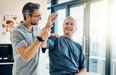 Riverside Manor, nursing home in Ames, IA — Physical therapy session between a caregiver and senior resident