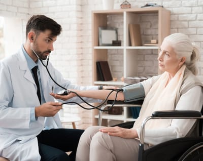 Riverside Manor, nursing home in Ames, IA — Healthcare professional checking blood pressure of a senior woman
