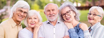 Riverside Manor, nursing home in Ames, IA — Seniors smiling and posing together outdoors in a park