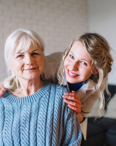 Riverside Manor, nursing home in Ames, IA — Smiling senior woman with caregiver in a cozy setting