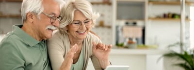 Riverside Manor, nursing home in Ames, IA — Senior couple video chatting with a tablet indoors