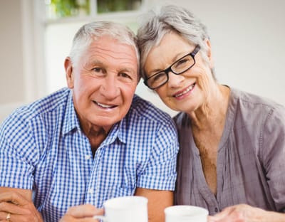 Riverside Manor, nursing home in Ames, IA — Smiling elderly couple enjoying coffee together in a cozy setting