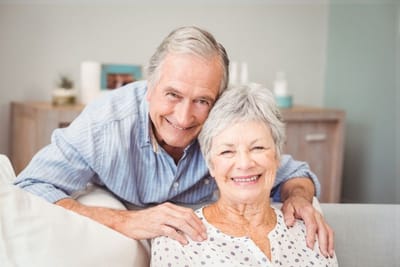 Riverside Manor, nursing home in Ames, IA — Smiling elderly couple posing together on a couch