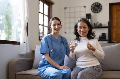 Riverside Manor, nursing home in Ames, IA — Nurse and resident smiling together in a cozy room