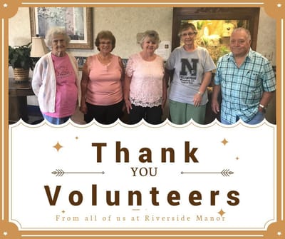 Group of smiling volunteers at Riverside Manor