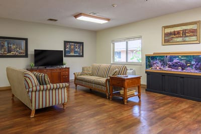 Bright common area with seating and an aquarium