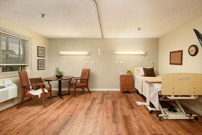 Well-furnished resident room with wooden flooring