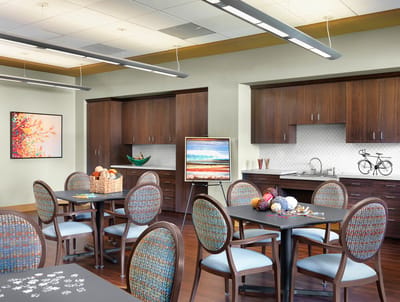 Bright common area with tables and paintings