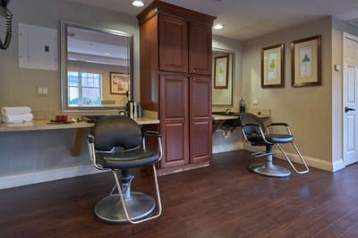 Interior view of a hair salon area with chairs and mirrors.