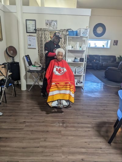 A resident getting a haircut in a common area