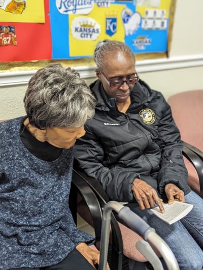 Two women reading together in a cozy space