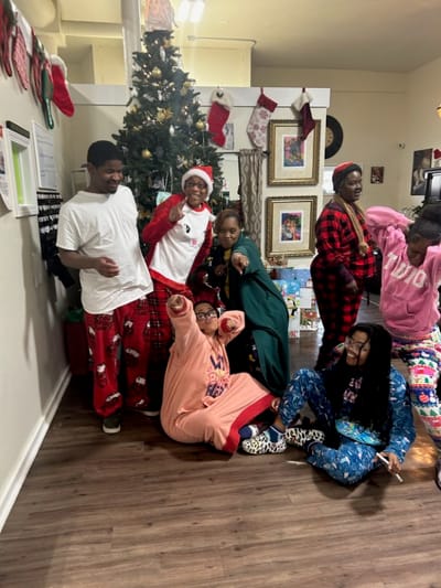 Residents and staff celebrating around a Christmas tree