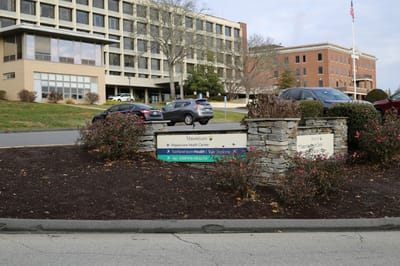 Signage indicating facility names at an outdoor entrance