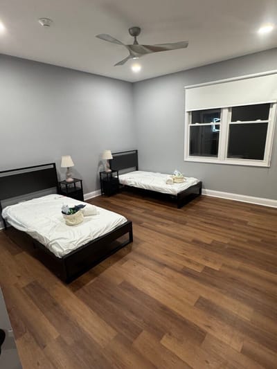 A bright, simple resident room with beds and lamps