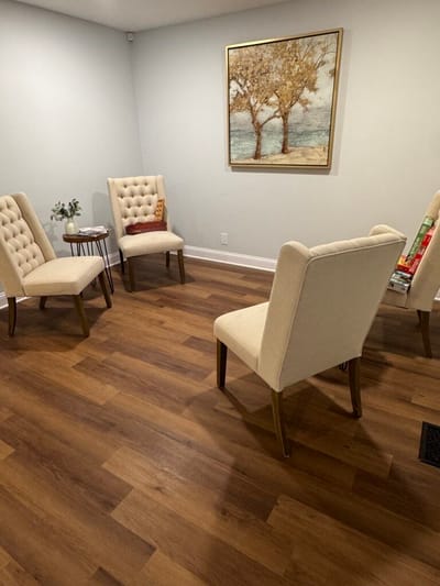 Seating area with chairs and a tree painting