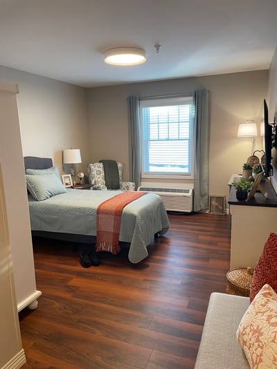 Cozy private resident room with a bed and seating area