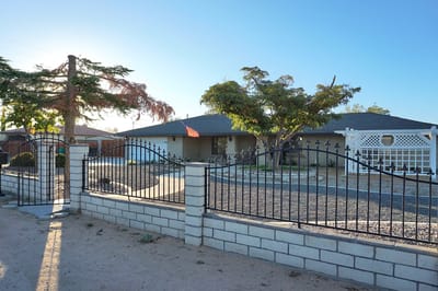 Exterior view of a senior living facility with garden and gate