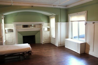 Empty resident room with wooden flooring and green walls