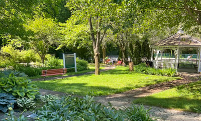 Outdoor seating area with gazebo and green space