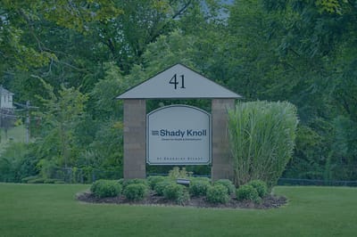 Signage for Shady Knoll Center in a landscaped area