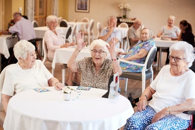 Residents enjoying bingo in a social activity room
